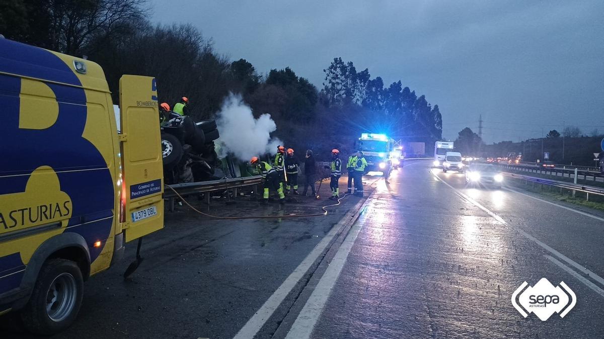 Los Bomberos junto al vehículo siniestrado.