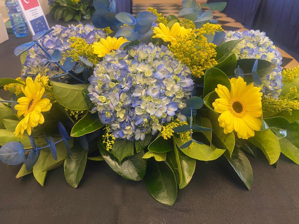 Centro de flores que adornaba la mesa de la reunión, amarillas y azules, los colores de la Unión Europea.