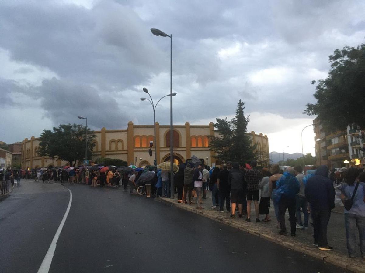 El público ha hecho fila para entrar con los paraguas.