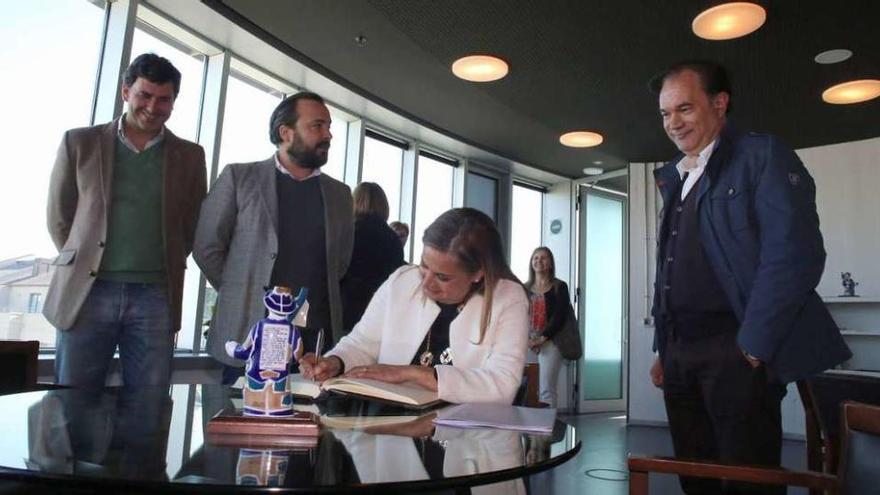 José Crespo (dcha.) observa a Carmela Silva mientras firma en el libro de honor de Lalín, en presencia de Rafael Cuiña y Nicolás González Casares. // Bernabé/Gutier