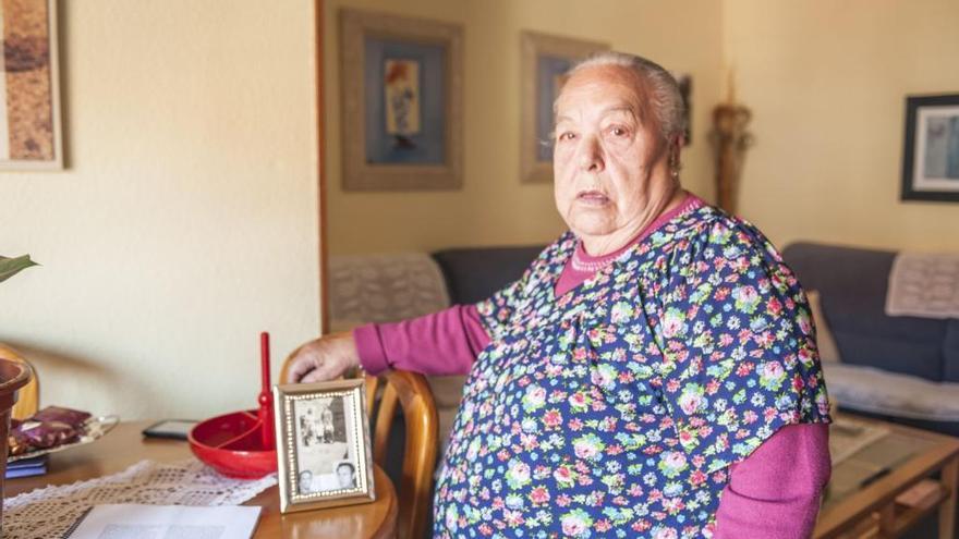 María Josefa Alonso Garea en su domicilio, con un retrato de sus padres con ella y su hermano pequeño. Debajo su marido ya fallecido.