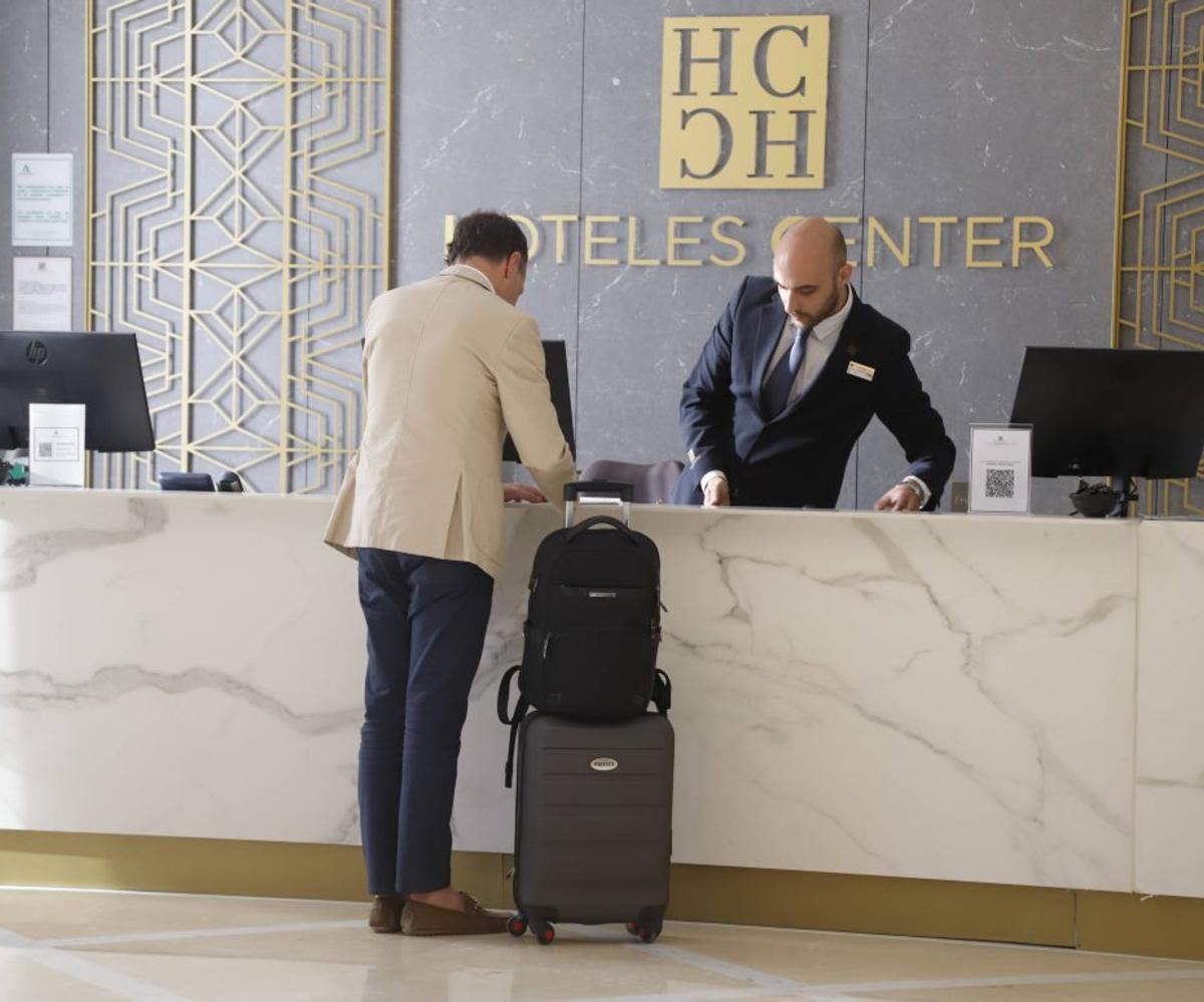 Un viajero es atendido en la recepción de un hotel.  | A.J. GONZÁLEZ