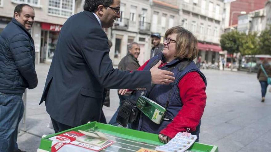 La vendedora, en su puesto de la Plaza Mayor, felicitada por el alcalde de Xinzo, Antonio Pérez. // Brais Lorenzo