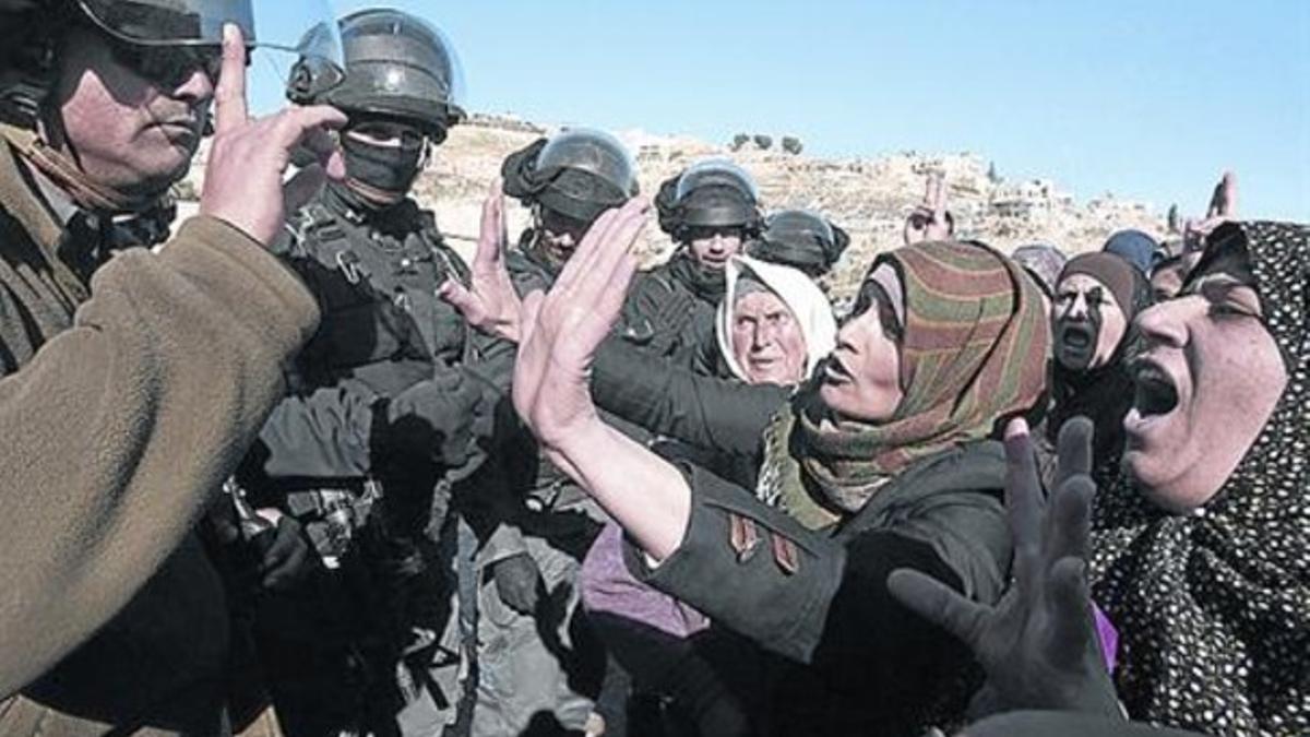 Mujeres palestinas se enfrentan a la policía israelí por una demolición.