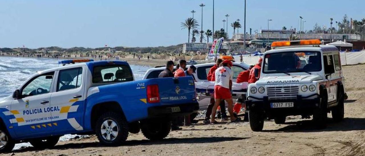 Operarios de Cruz Roja trasladan uno de los cadáveres, ayer, en la Playa del Inglés. // La Provincia