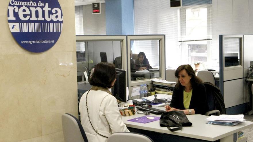 Una mujer pide información en una oficina para hacer su declaración de la renta.