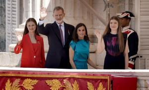 Los Reyes y sus hijas saludan desde el Palacio Real durante la celebración del 10º aniversario de la proclamación de Felipe VI