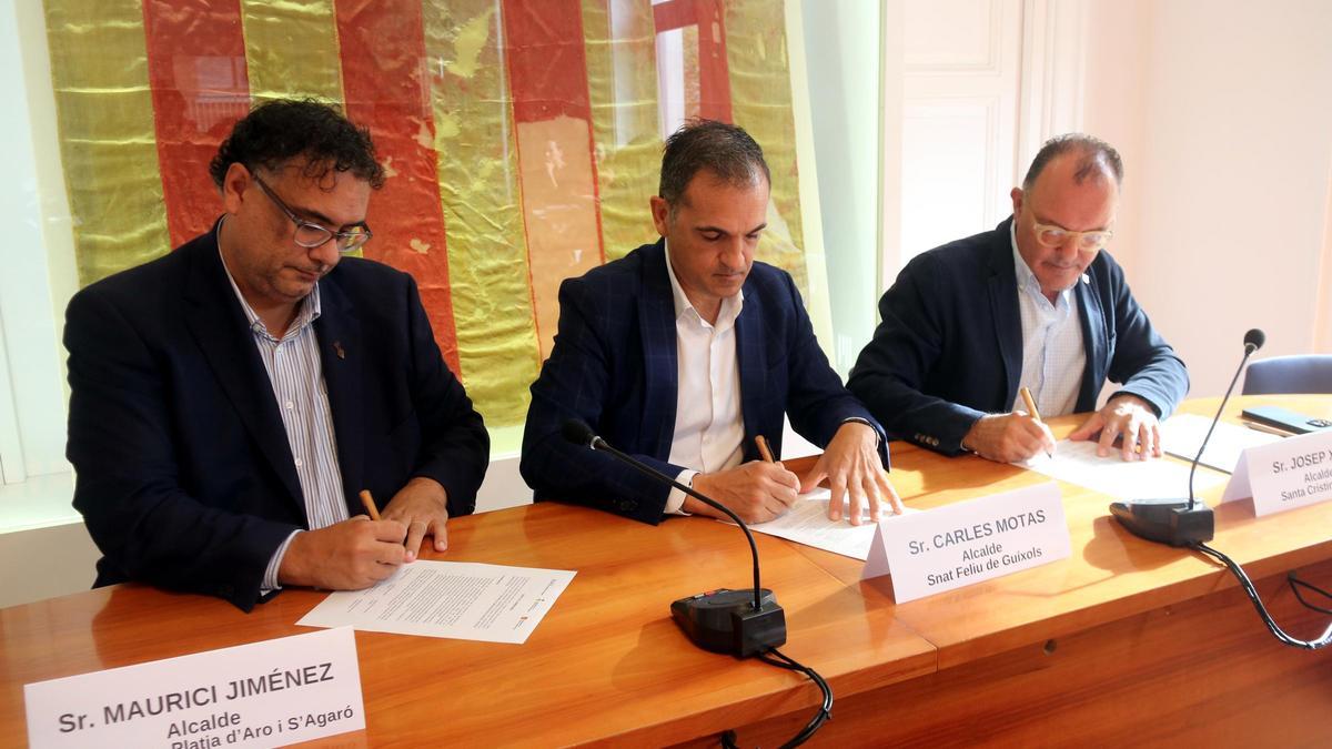 Els alcaldes de Platja d'Aro, Sant Feliu de Guíxols i Santa Cristina d'Aro, signant el conveni entre els tres municipis