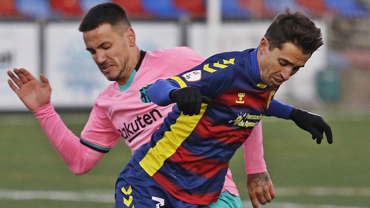 El golejador bregant una pilota amb un jugador del Barça B en el partit d?ahir.