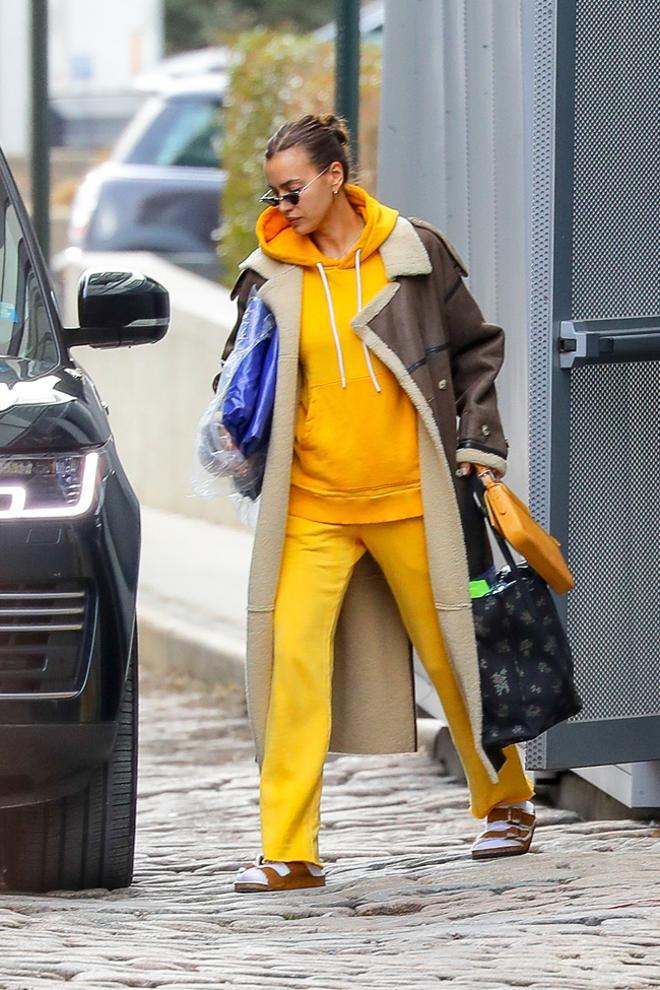 Irina Shayk con chándal amarillo y abrigo largo de doble faz