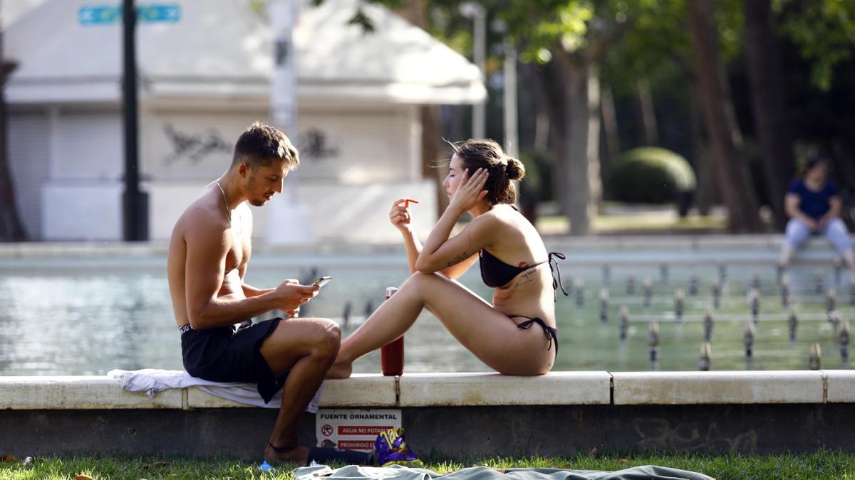 Una pareja toma el sol en el Parque Labordeta de Zaragoza