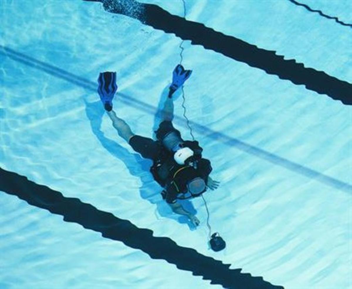 Un submarinista instal·la una de les sofisticades càmeres submarines de TVE a la piscina del Palau Sant Jordi. Un submarinista instal·la una de les sofisticades càmeres submarines de TVE a la piscina del Palau Sant Jordi.
