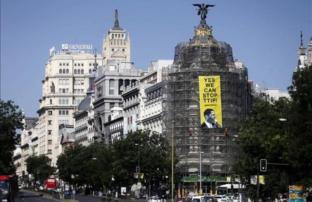 Fotografía facilitada por Greenpeace de la pancarta que seis escaladores de la organización ecologista han colgado este mediodía en el edificio Metropolis de la Gran Via madrileña con el mensaje Si podemos parar el TTIP ,Tratado Transatlantico de Comercio e Inversiones entre Europa y Estados Unidos , dirigido al presidente estadounidense Barack Obama  