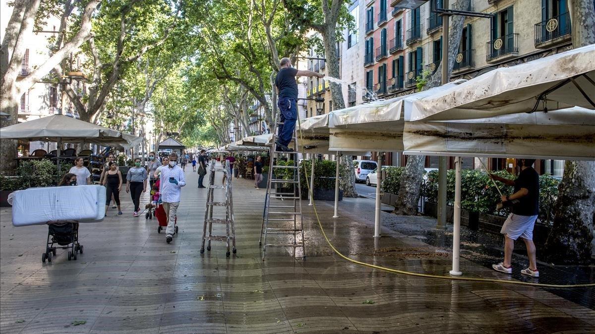 Las terrazas de Las Ramblas se desperezaban, el pasado 22 de mayo, para estar presentables para el público local en la fase 1 de la desescalada, a la espera de que llegue su cliente favorito.