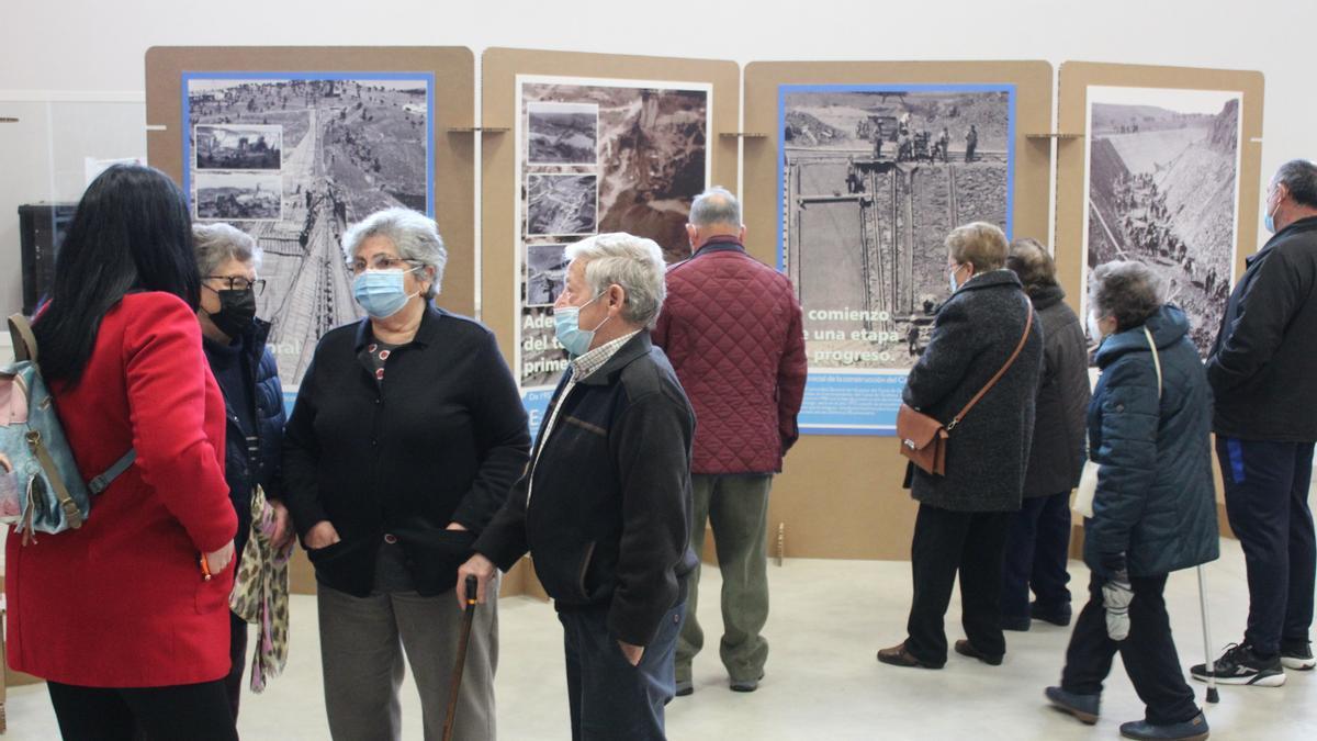 Un grupo de visitantes observa uno de los paneles fotográficos de la exposición