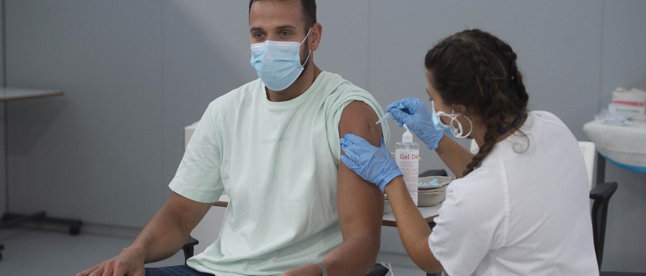 Un joven recibe la vacuna Pfizer.