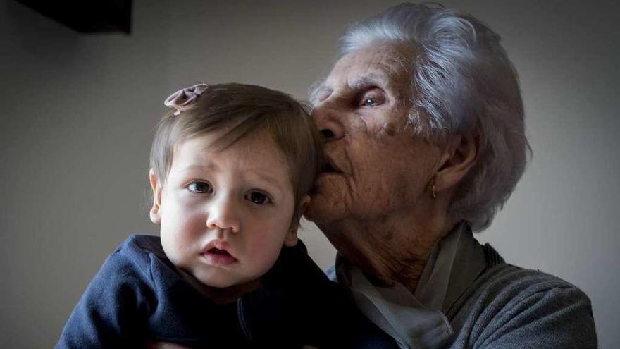 Dora Vázquez, 101 años, besa a su bisnieta Lucía de 1 año, en su regazo. // Brais Lorenzo