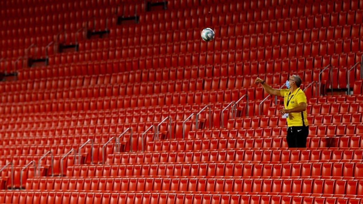 Un empleado del Sevilla devuelve una pelota al césped desde la tribuna vacía en el reciente Sevilla-Barça (0-0).