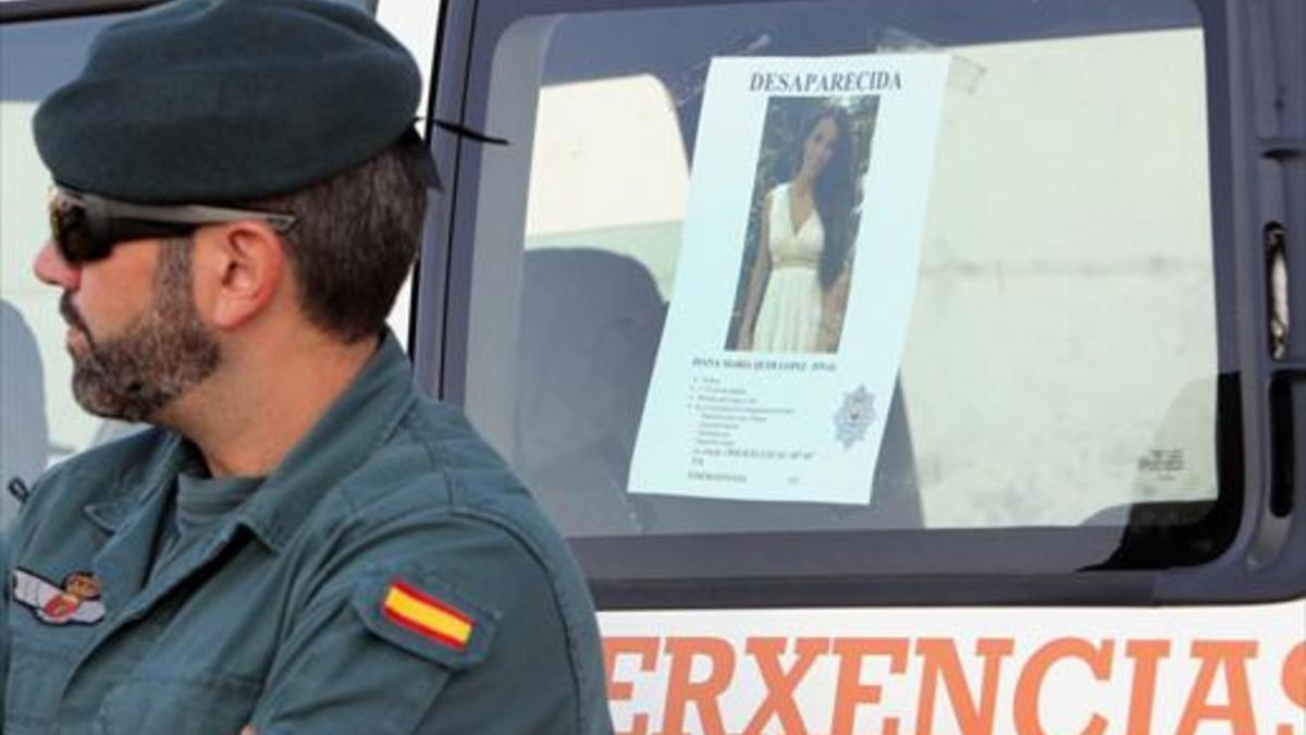 Un agente de la Guardia Civil, el 1 de septiembre, junto al cartel de búsqueda de Diana Quer, desaparecida en A Pobra do Caramiñal (A Coruña).