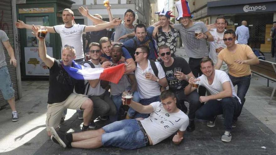 Los aficionados franceses posan con la bandera gala en el centro de A Coruña.