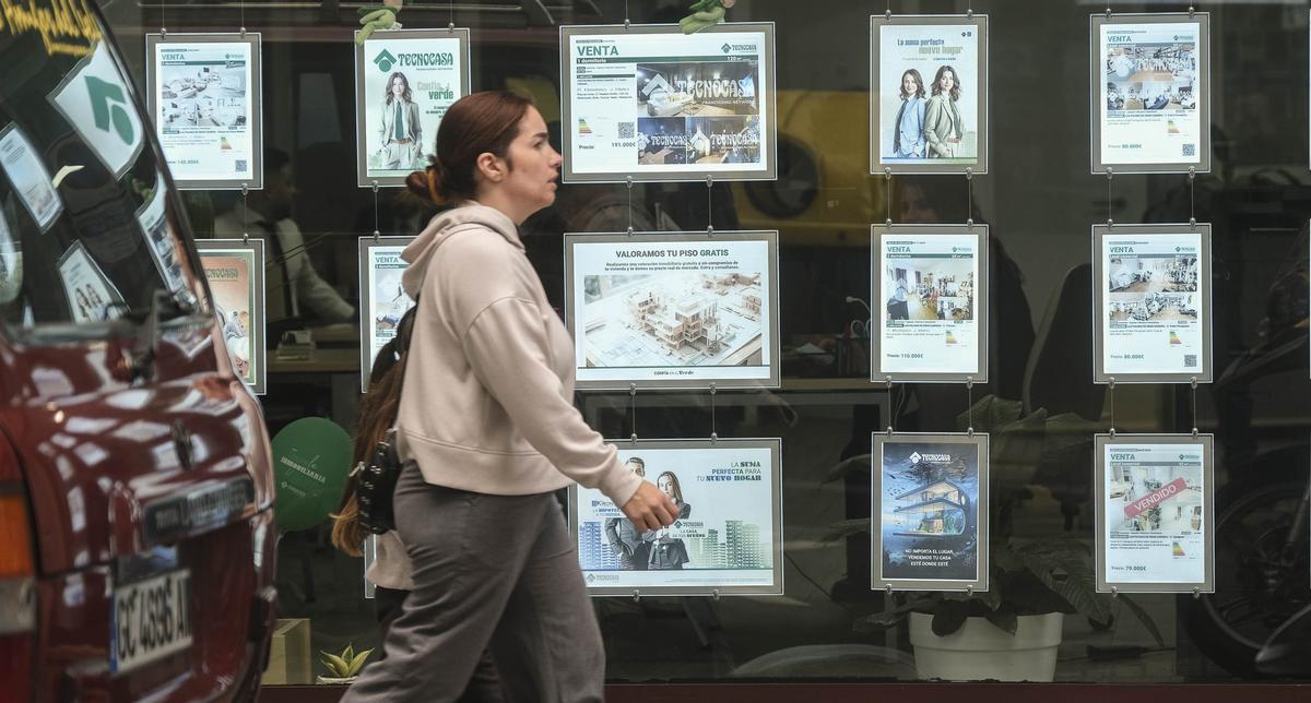 Una mujer pasea por delante de una agencia inmobiliaria en Canarias.