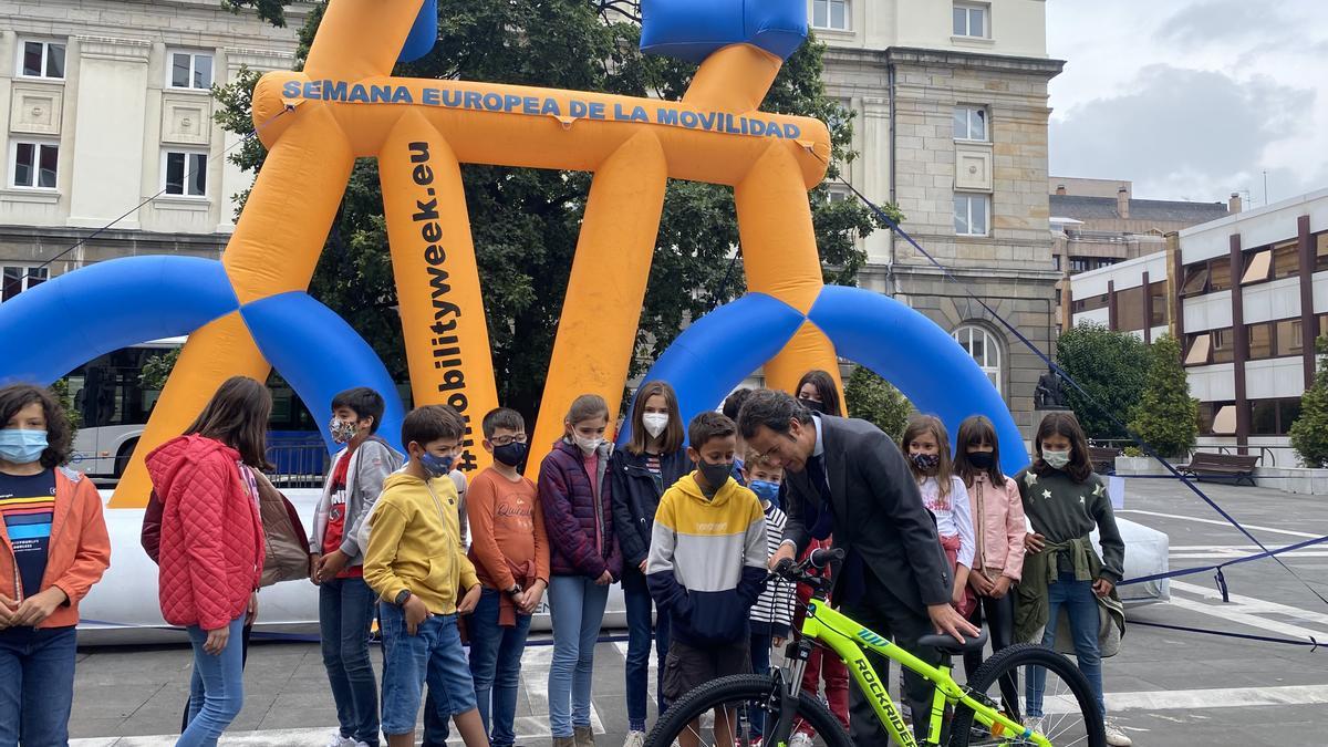 Nacho Cuesta le entrega una bicicleta a Nicolás Fernández Río, ganador del concurso &quot;el autobús es tuyo&quot;