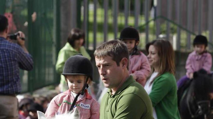 Tres alumnos de la escuela infantil, a lomos de los ponis.