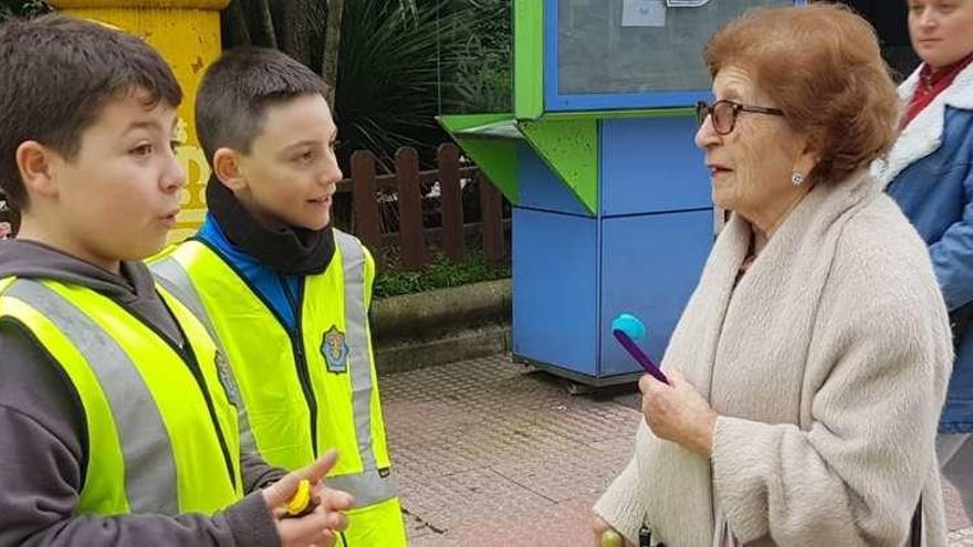 Dos escolares &#039;hacen&#039; de policías y entregan una flor a una peatón por buen comportamiento vial.