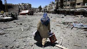 A Lebanese woman, carrying some belongings, flees the southern town of Bint Jbail, Lebanon, site of a weeklong siege by Israeli forces, Monday July 31, 2006.Trapped in Bin Jbail, the epicenter and the scene of the bitterest fighting between Hezbollah and the Israeli forces the old, the infirm, women with children fled from their shattered homes. Buildings were collapsed on to each other, the faces of others were sheared off, fallen power lines crisscrossed the street. (AP Photo/Lefteris Pitarakis)