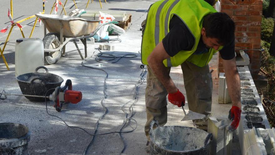 Operari treballant en l&#039;arranjament de la barana del passeig de la Indústria, el Vall.