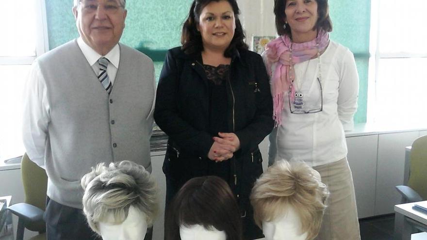 Maria Rosa López (c), con tres pelucas donadas a la AECC.