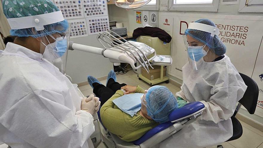 Voluntaris de Dentistes Solidaris atenent un pacient a la clínica, situada al Mercat del Lleó.