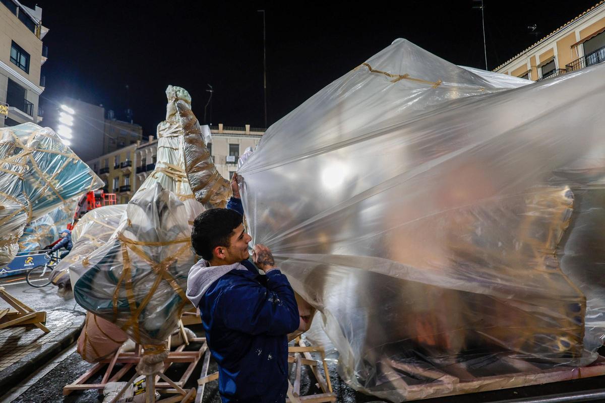 La lluvia obliga a tapar con plásticos los primeros ninots de las fallas llegados a las comisiones.