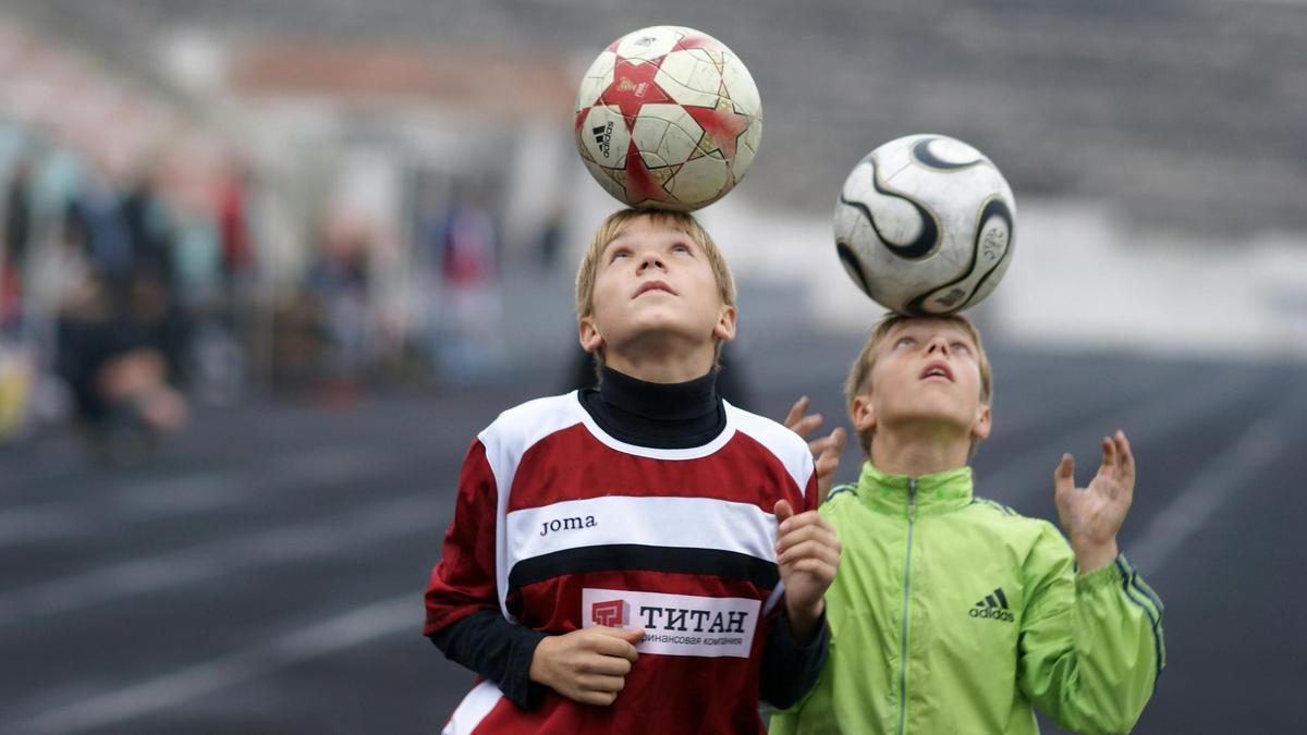 Niños dando toques al balón con la cabeza