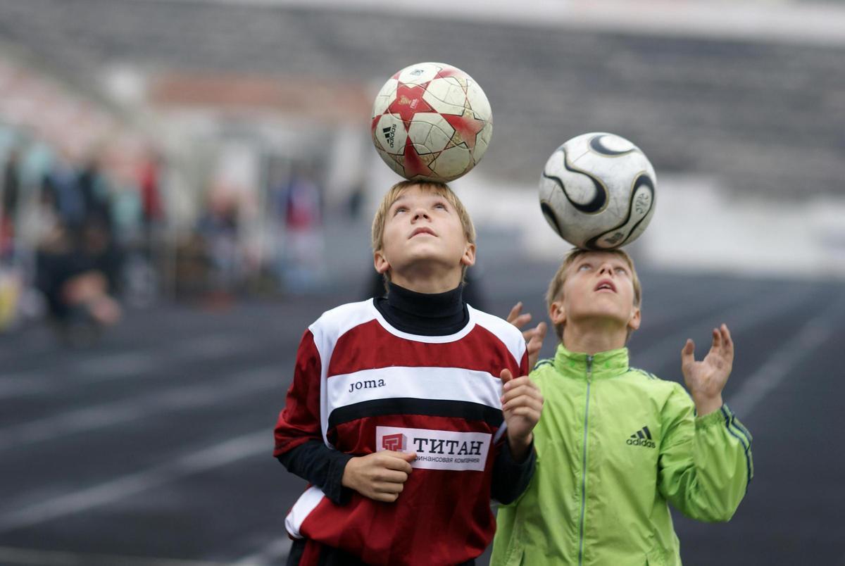 Niños dando toques al balón con la cabeza