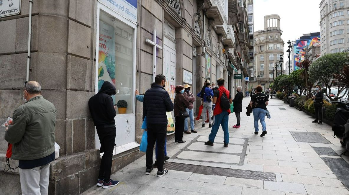 Un grupo de personas espera el reparto de alimentos en el comedor de las Misioneras del Silencio. ALBA VILLAR