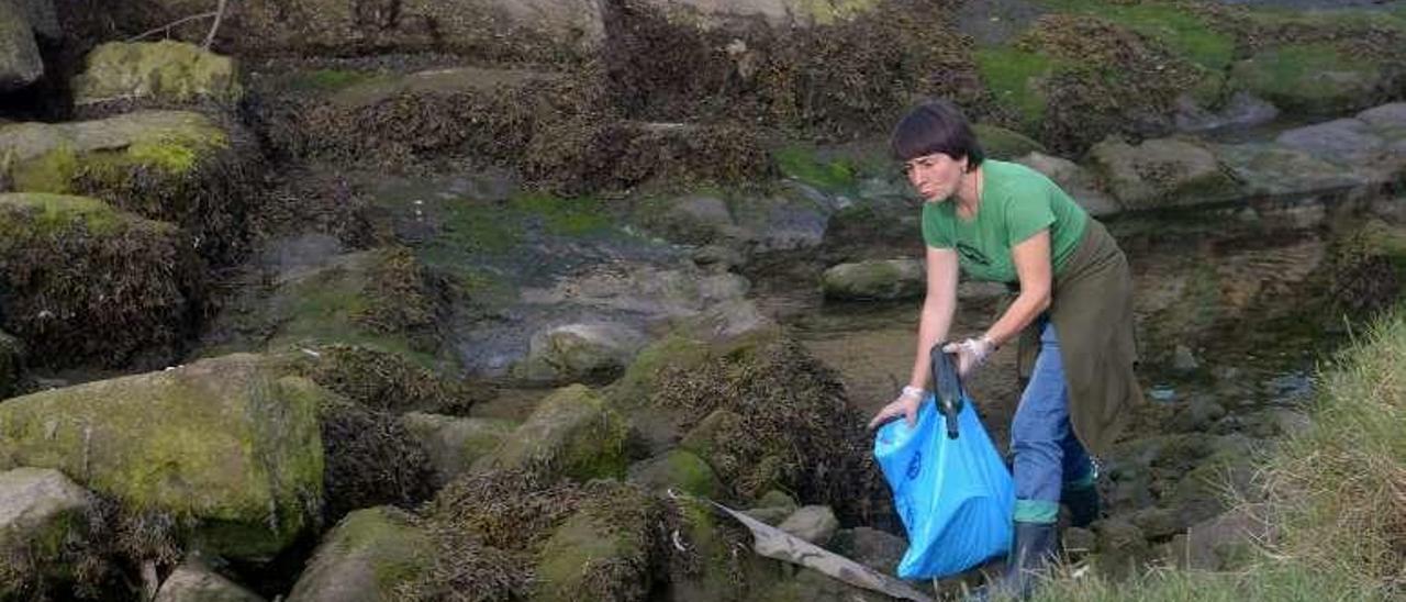 Una voluntaria recoge la basura hallada en el cauce. // Noé Parga