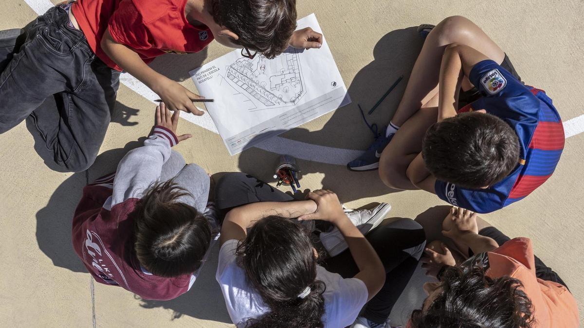 Un grupo de niños en el patio de una escuela.