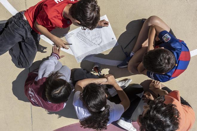 Un grupo de niños en el patio de una escuela.