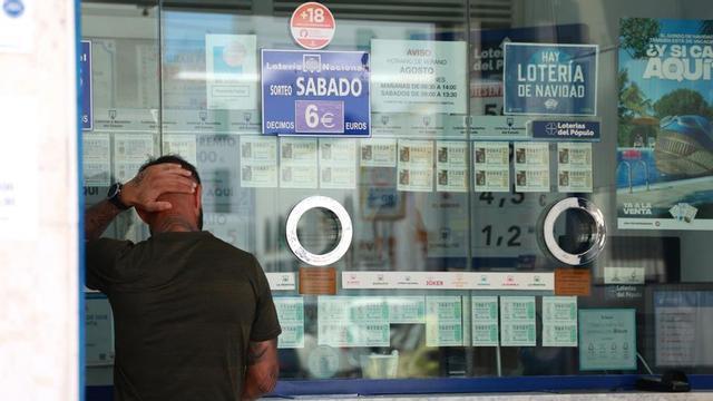ArUna persona se dispone a adquirir un boleto en una Administración de Loterias.