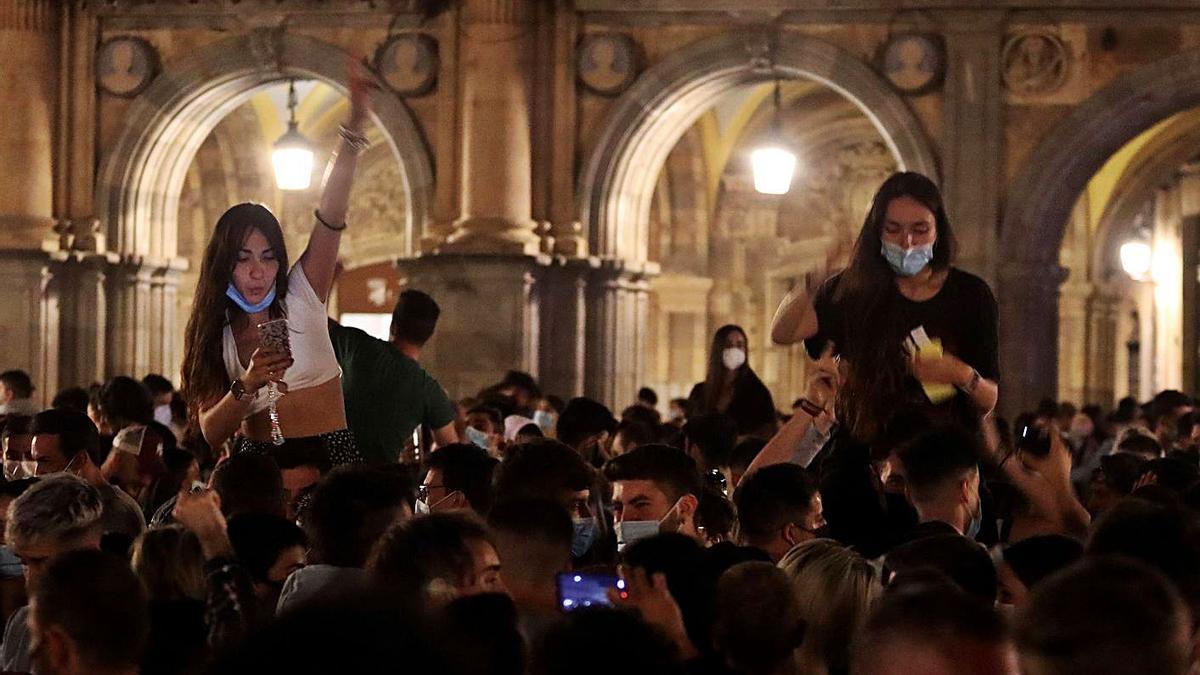 Dos jóvenes celebran el final del estado de alarma en la Plaza Mayor de Salamanca.