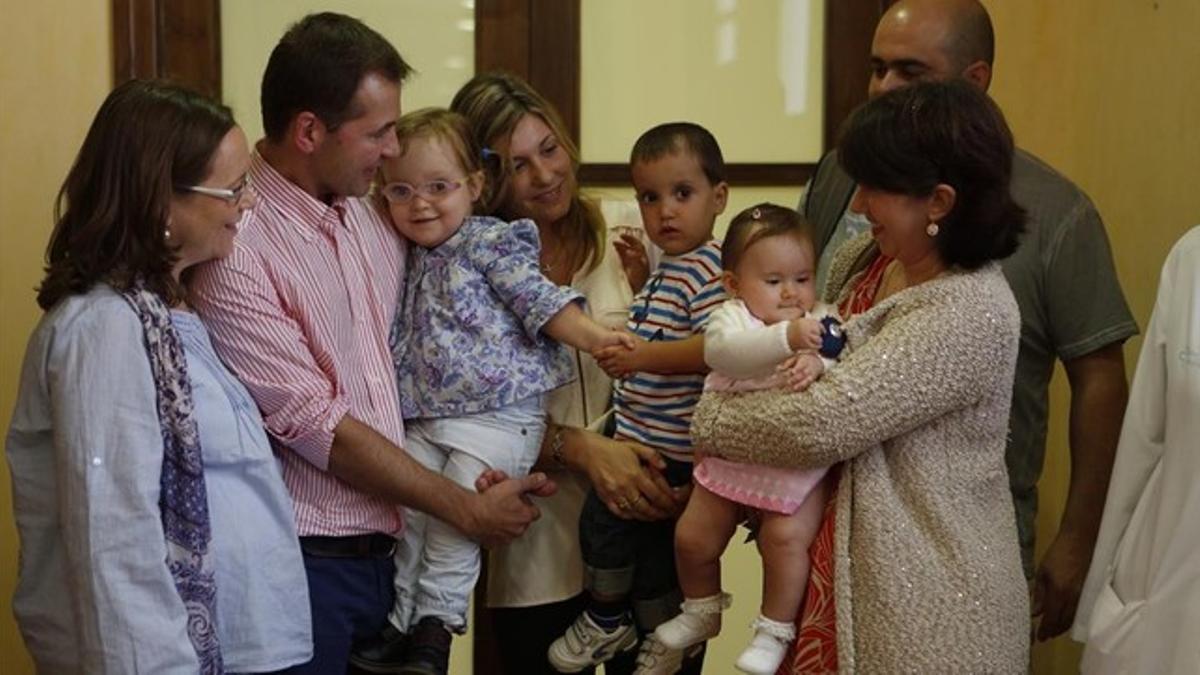 Tres niños operados en Vall d'Hebron de espina bífida con sus familiares.