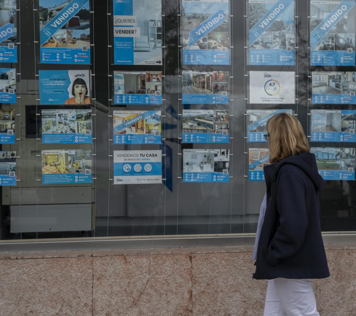 Una mujer observa el escaparate de una inmobiliaria en Santander