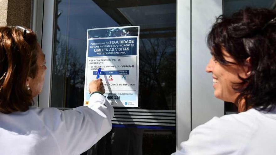Personal del ambulatorio Virxe Peregrina junto a uno de los nuevos carteles informativos en el exterior del edificio. // Gustavo Santos