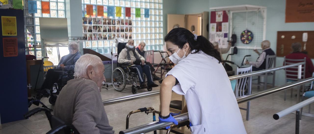 Una cuidadora ayuda a una persona mayor en la residencia Montesol de L’Eliana, durante la pandemia.