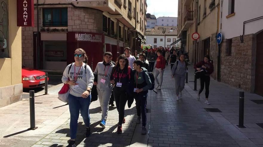 Participantes en la marcha, a su salida de Cangas de Onís. A la derecha, monitores dando instrucciones.