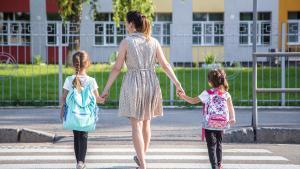 Una madre lleva a sus dos hijas al colegio.
