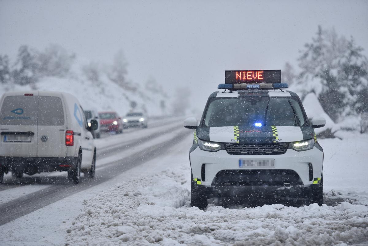 Un coche de policía aparcado en una carretera nevada, en Huesca.