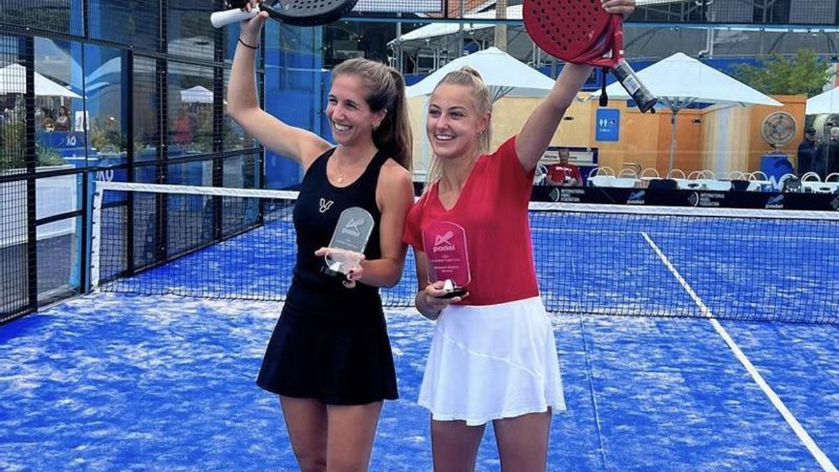 Nerea Guerra (derecha) y Constanza Sampaio saludan al público con sus trofeos de campeonas.