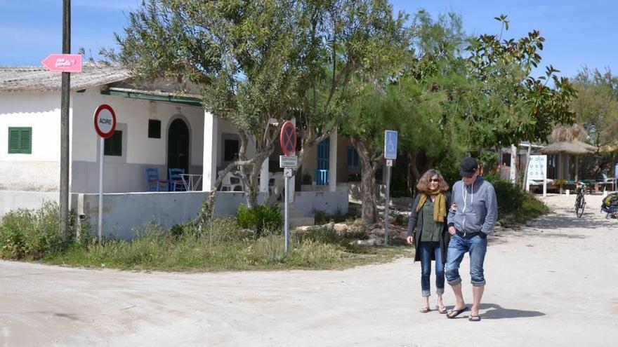 Dos personas pasean por las calles sin asfaltar de los pequeños chalés que ya colman la zona de sa Caseta dels Capellans.